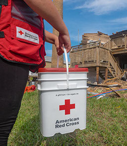 September 2, 2017. Port Aransas, Texas. Red Cross volunteer carries a cleanup kit to a home in Port Aransas, Texas. Photo by Chuck Haupt/American Red Cross